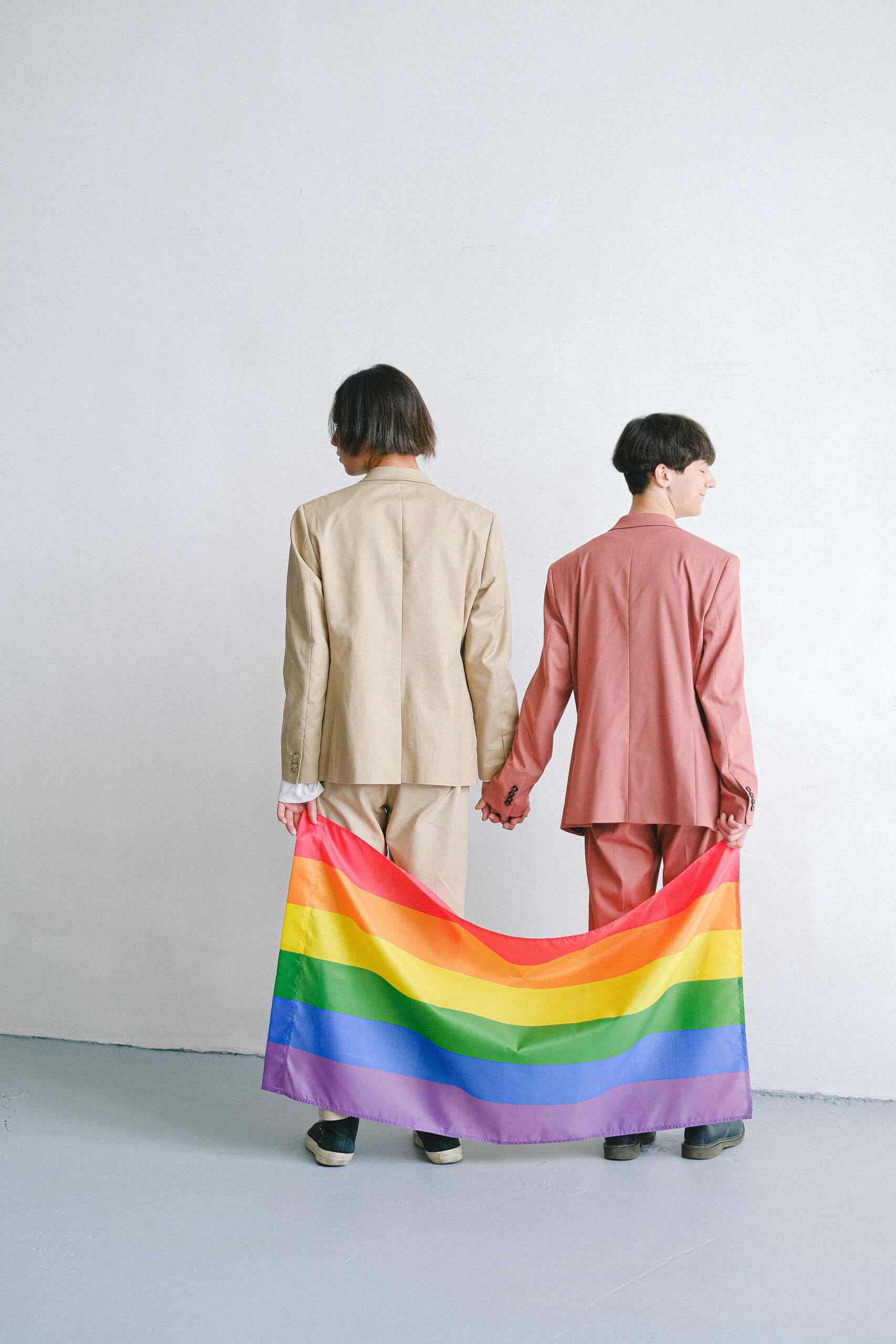 Two people holing hands and a Pride flag