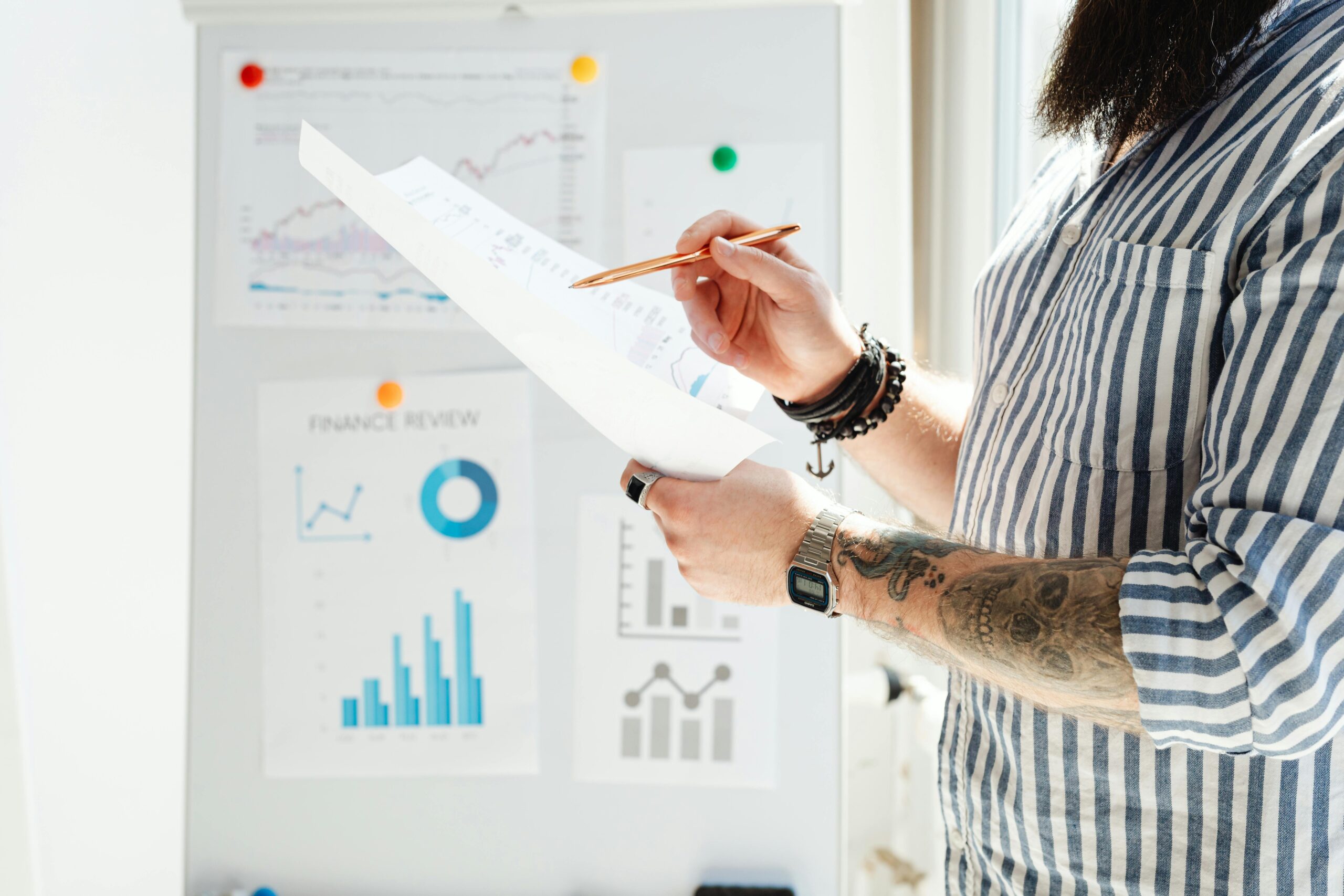 Man in White and Blue Stripe Shirt Holding White Printer Paper